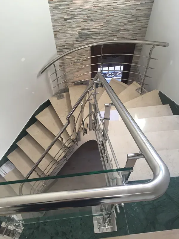 Pasamanos curvo con vidrio en escalera