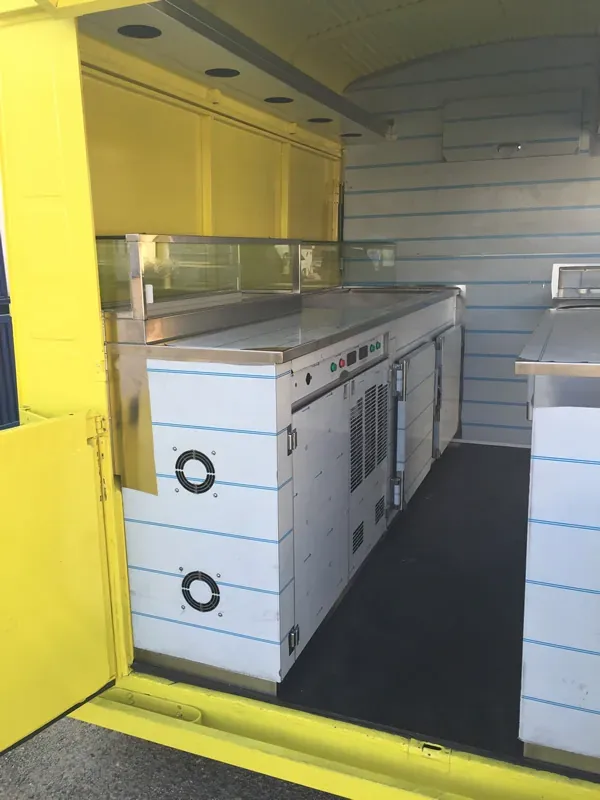 Food truck amarillo con cocina en acero inoxidable